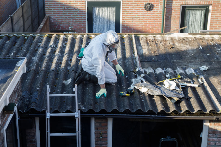 Man cleaning debris off roof